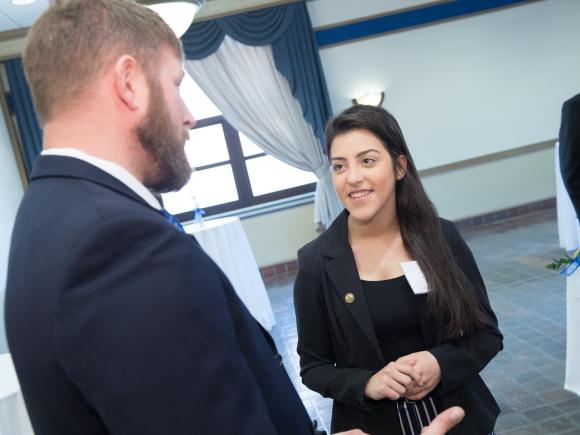 Student engaging in conversation with another participant at an event.