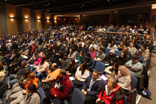 Room full of prospective students listening to an admissions presentation during an on-campus open house.