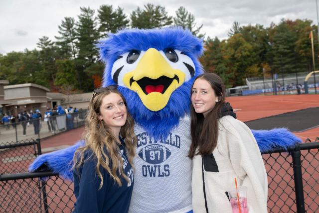 Two students smiling with WSU mascot Nestor.