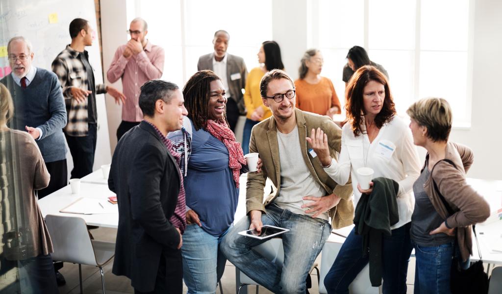 class session with people standing and talking in small groups